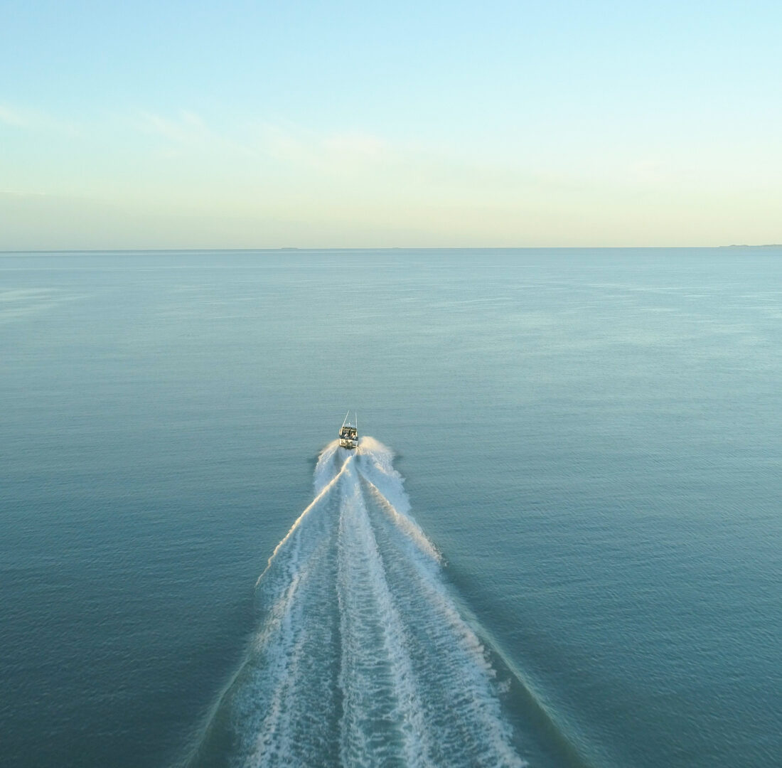 Een boot die vaart richting de horizon